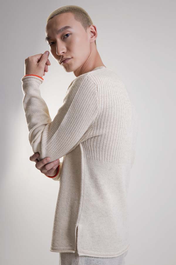 Model in a cream rib-knit Sartuul wool sweater against a light grey background