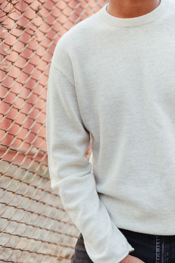 Man wearing an ecru fully fashioned cashmere crew neck sweater